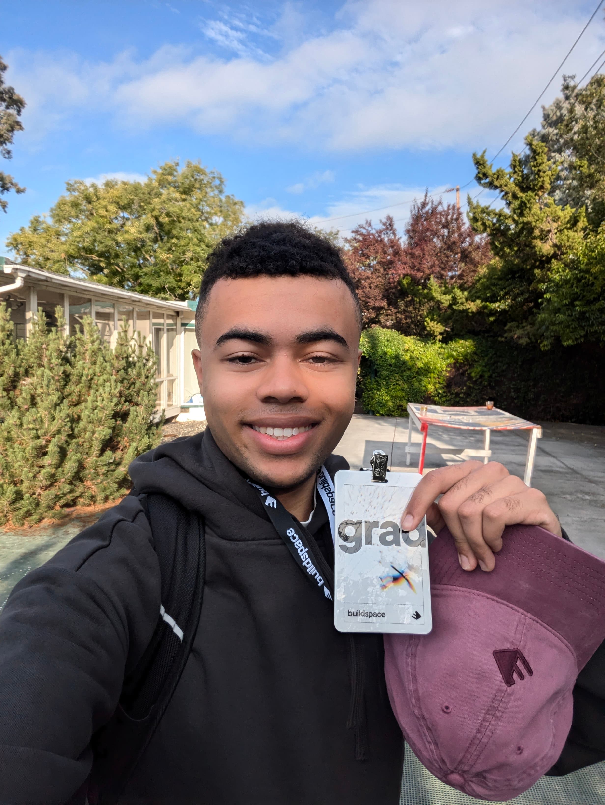 Ehab James at Buildspace in San Francisco, holding his graduate badge